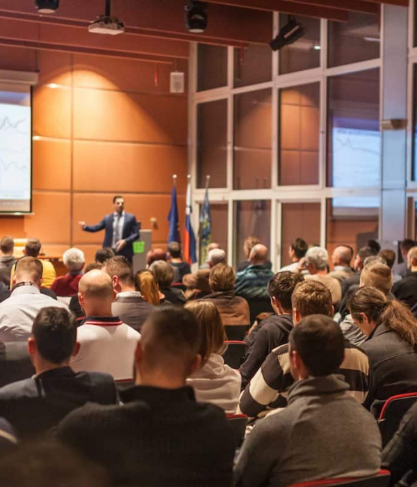 Speaker giving a talk in conference hall at business event. Audience at the conference hall. Business and Entrepreneurship concept.